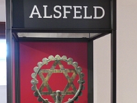 Alsfeld hatte eine große und wohlhabende jüdische Gemeinde. Diese weihte 1905 eine neue Synagoge ein - ein repräsentativer Neubau mit bis zu 350 Plätzen. Der ausgestellte Davidstern war an der Spitze des Daches angebracht. Leider blieb auch die Alsfelder Synagoge nicht von den Pogromen der Nationalsozialisten im Jahr 1938 verschont. Zwar blieben einige Mauern stehen und Torarollen sowie der Toraschrein konnten gerettet werden (sie befinden sich noch immer im Bestand des Stadtmuseums Alsfeld). Doch der menschenverachtende Angriff leitete das jähe Ende jüdischen Lebens und jüdischer Kultur in Alsfeld ein.