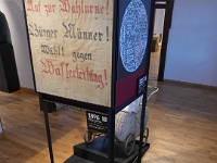 1896 beginnt der Aufbau der städtischen Wasserversorgung. Das klingt aus heutiger Perspektive gut. Doch damals formierte sich zunächst unter dem Motto "Brouche mer e Wasserleiring - mehr ho de Bomb verm Haus" Widerstand. Das zeigt auch das ausgestellte Tuch mir der Aufforderung, gegen den Bau der Wasserleitung zu stimmen. Trotz dieser Proteste wurde 1896 mit dem Bau begonnen. Die Alsfelder werden sich dann sicher schnell daran gewöhnt haben.
